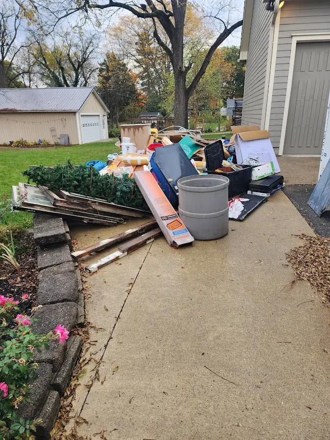 Dumpster being loaded with debris for Estate Cleanout Dumpster Rental in Marinette